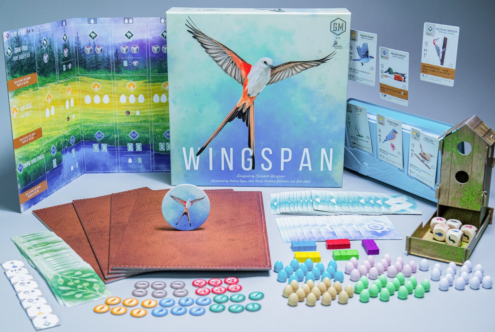 Componentes de Wingspan con comedero, huevos, cartas y tableros