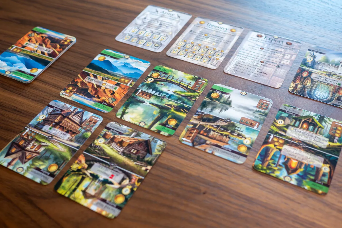 Cartas de edificios y territorios desplegadas durante una partida de Kingdom Legacy